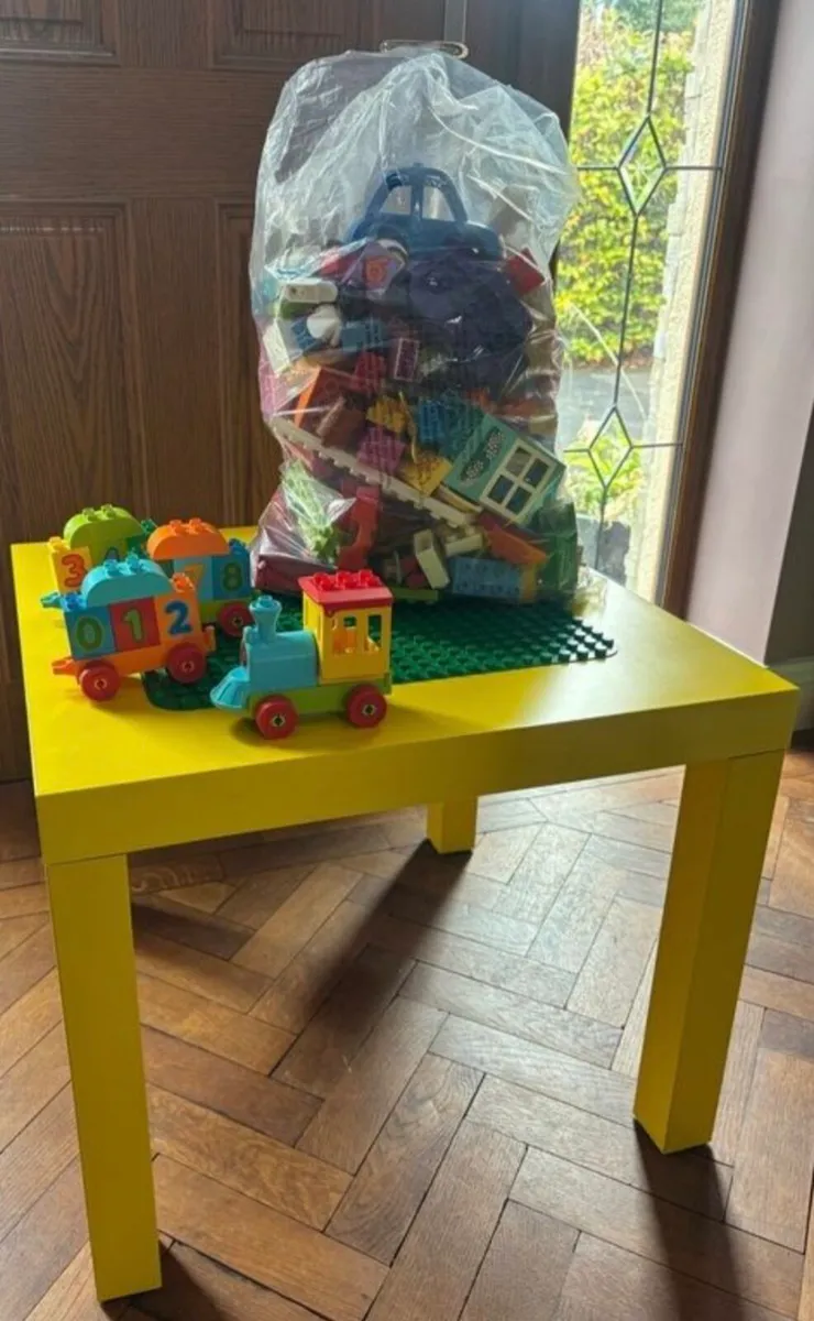 Large bag of duplo,  yellow ikea table. Green d
