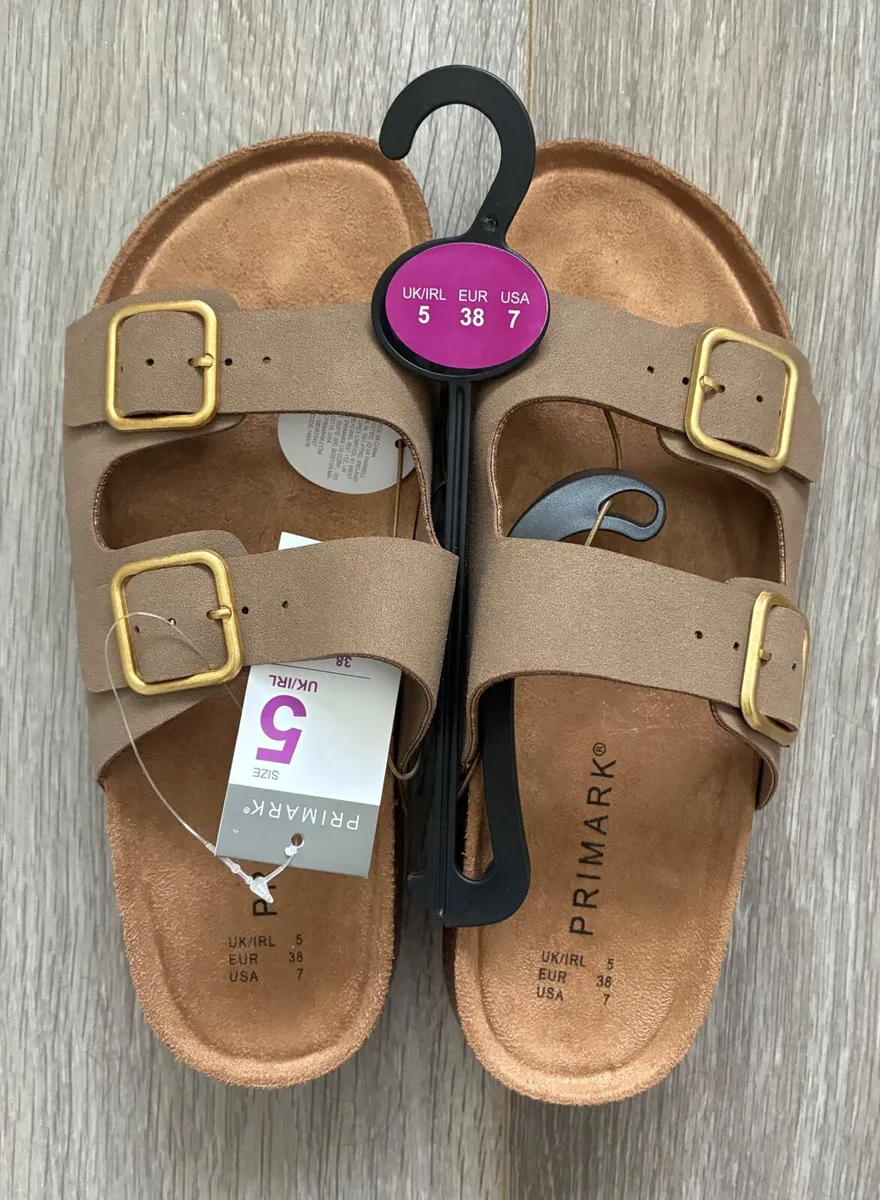 Taupe double-buckle strap mule sandals feature adj