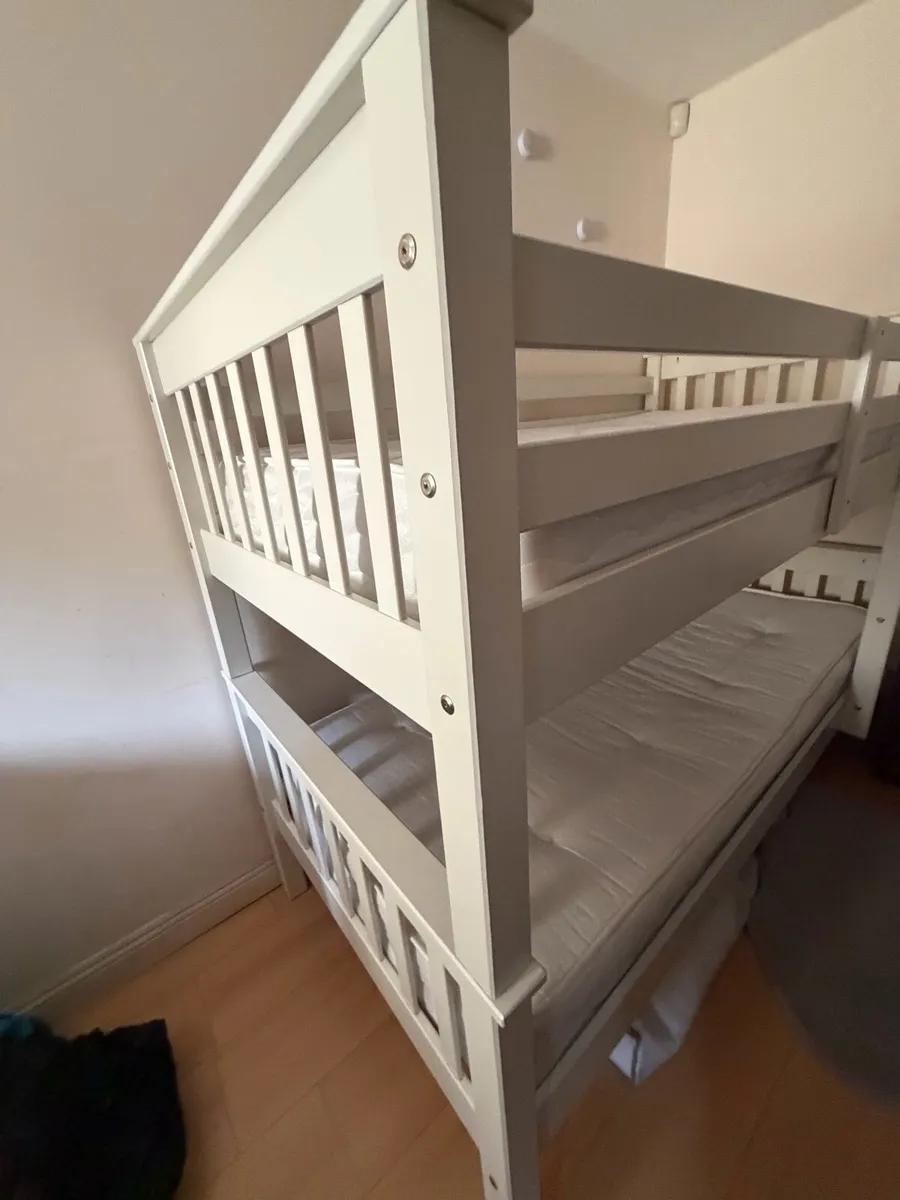White wooden bunk bed with mattresses. - Image 1