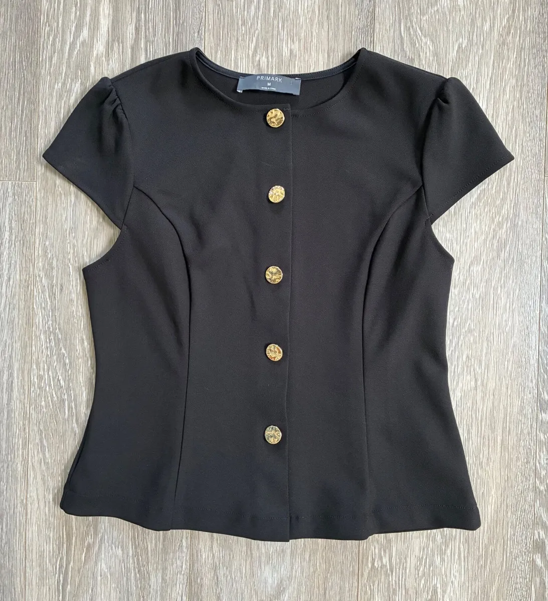 Black button-up top features a round neckline and