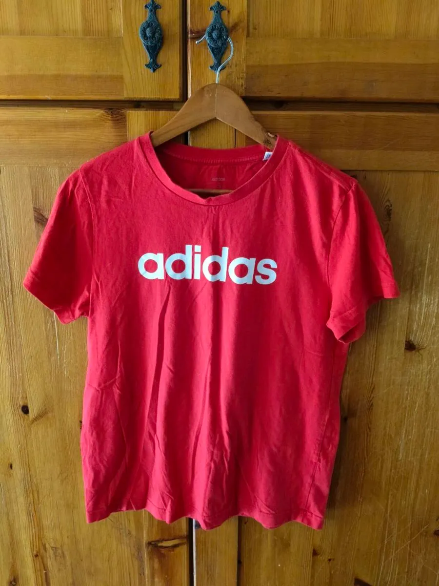 red Adidas t-shirt features a prominent white logo - Image 1