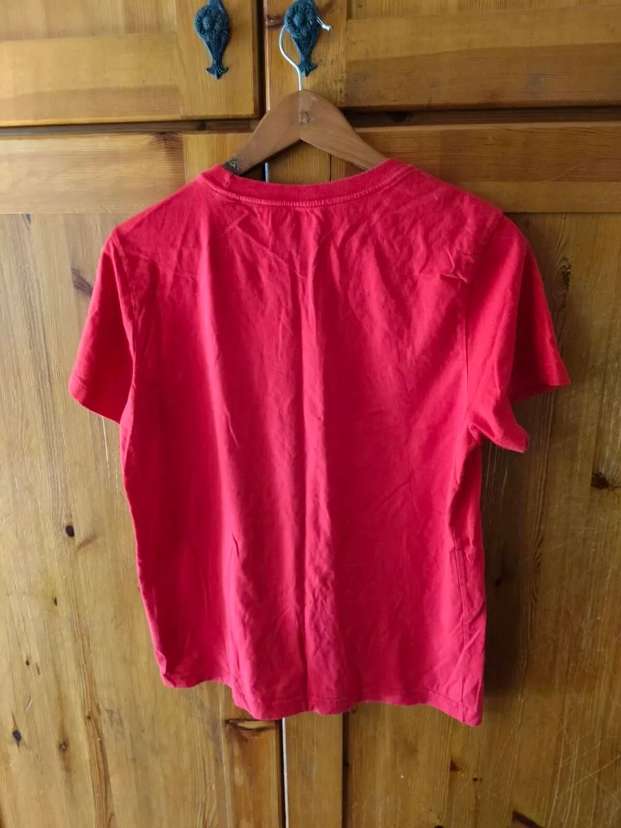 red Adidas t-shirt features a prominent white logo - Image 2