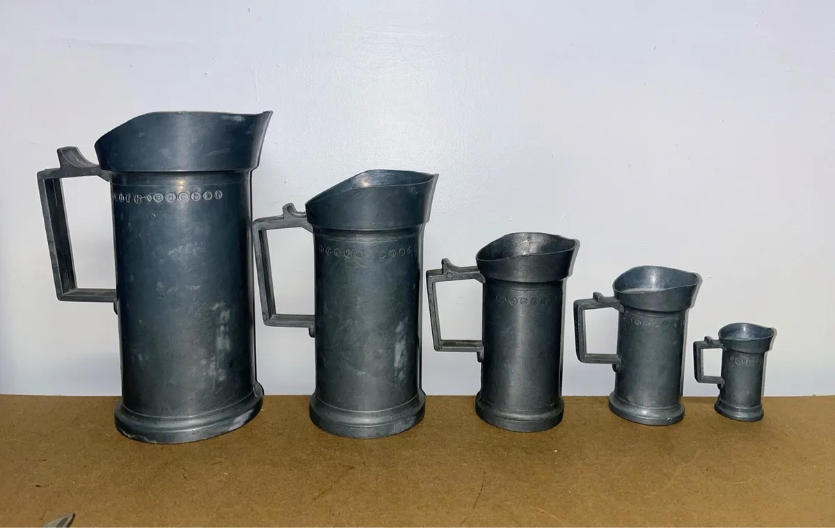 Five graduated measuring jugs