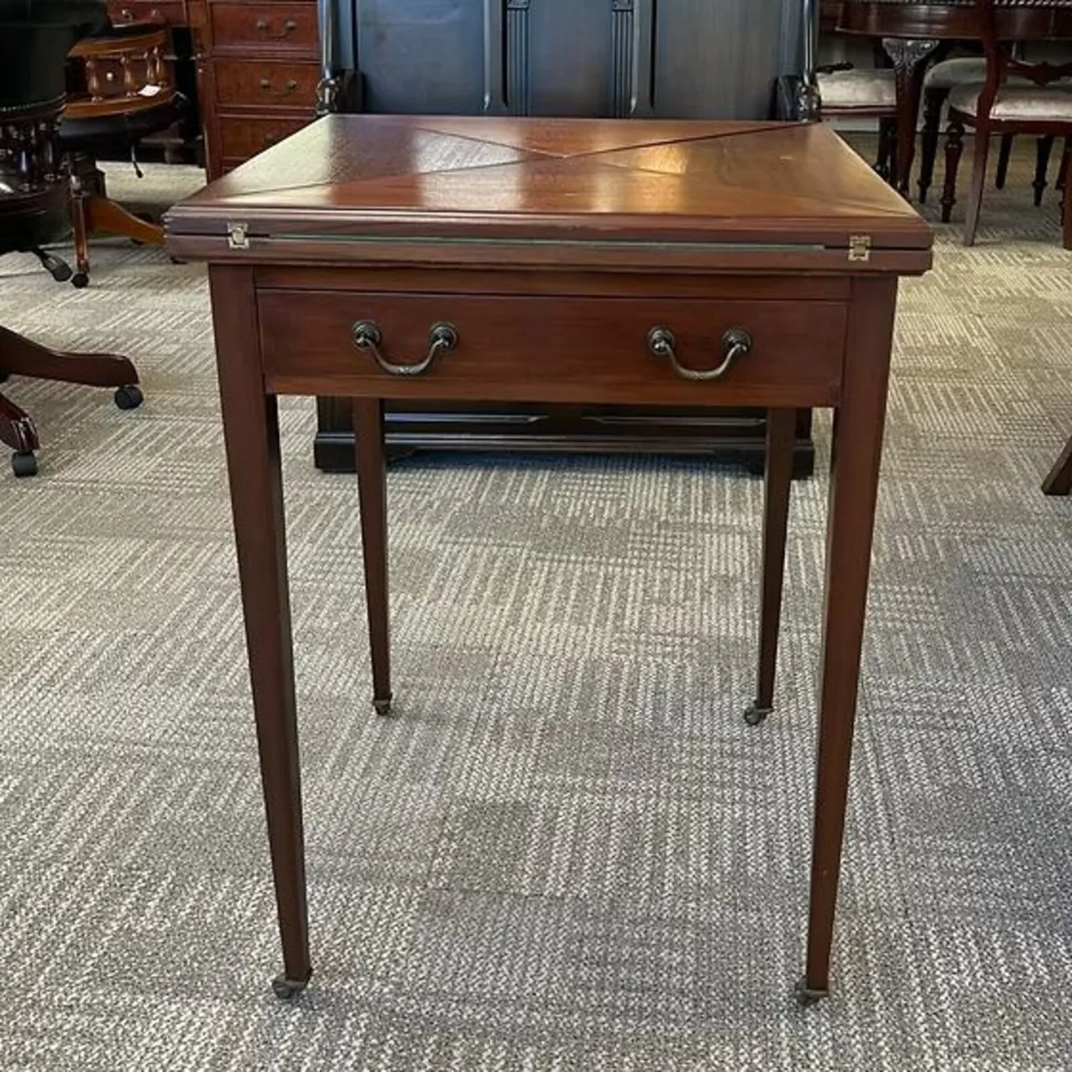 Edwardian mahogany games envelope table, with draw